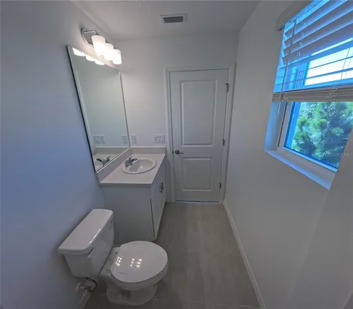 a bathroom with a toilet a sink and a mirror