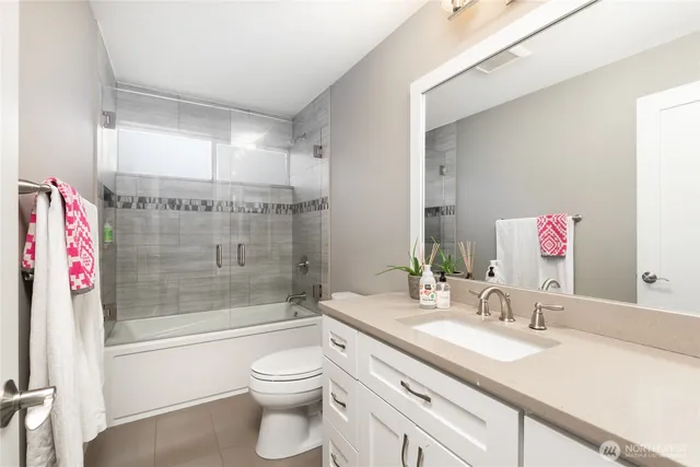 a bathroom with a granite countertop sink a toilet and shower