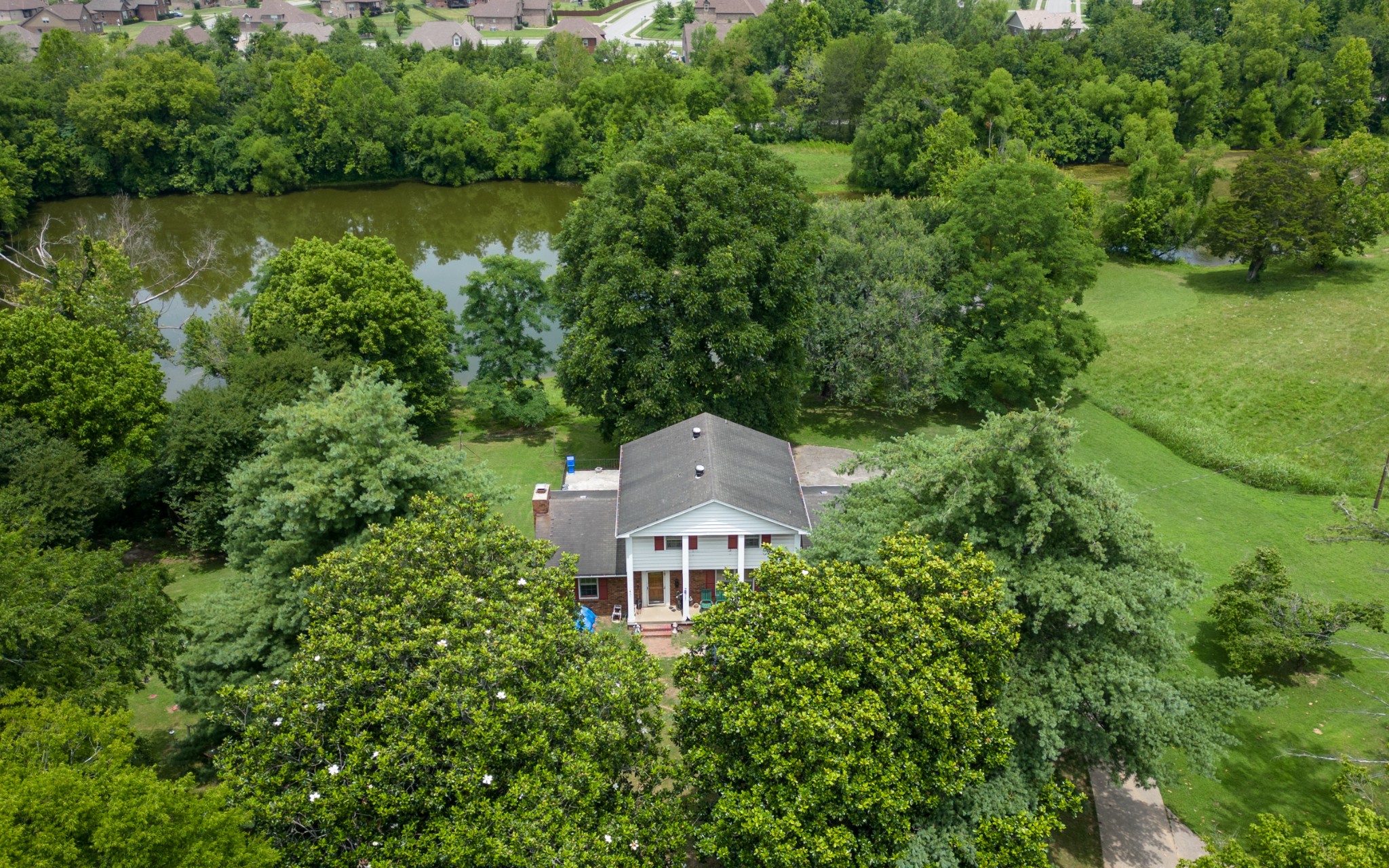 an aerial view of a house with a yard and lake view