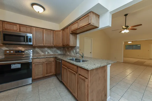a kitchen with a sink a stove and cabinets