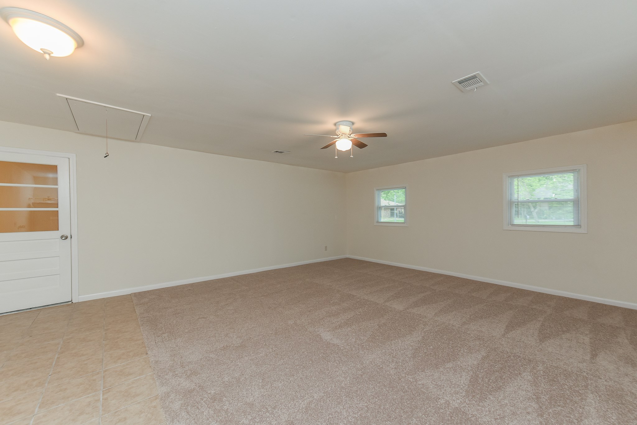 18610 Anne Drive Webster, TX 77058 - Photo 35 of 50 an empty room with windows and chandelier fan