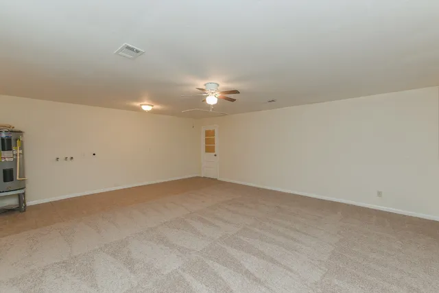 an empty room with a ceiling fan and a window