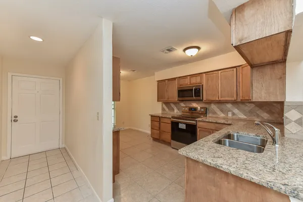 a kitchen with stainless steel appliances granite countertop a sink stove and microwave