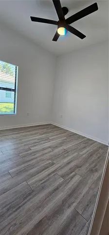 a view of an empty room with wooden floor and closet