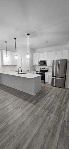 a large kitchen with stainless steel appliances kitchen island granite countertop a refrigerator stove a sink and dishwasher