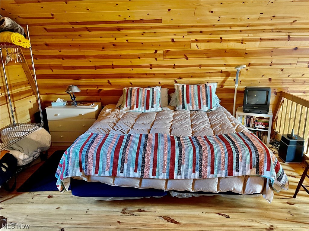 43188 Krieg Road New Matamoras, OH 45767 - Photo 21 of 35 Hardwood floored bedroom featuring wooden walls and wooden ceiling