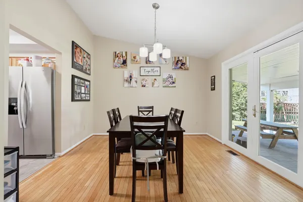 a view of a dining room and livingroom with furniture wooden floor and a painting