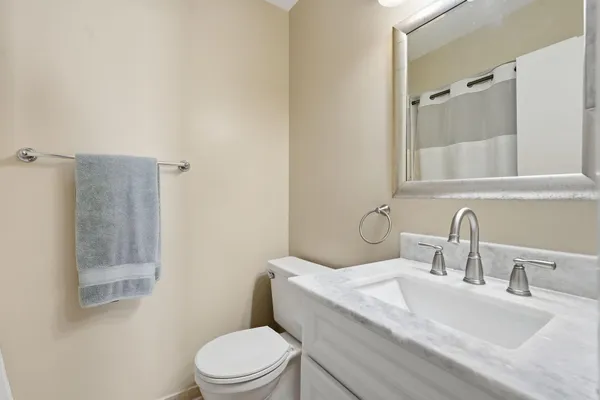 a kitchen with stainless steel appliances kitchen island granite countertop a refrigerator a stove and a wooden floors