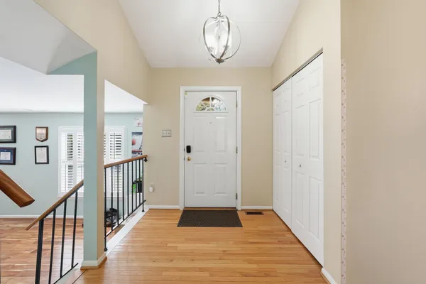 a view of a hallway with wooden floor and stairs