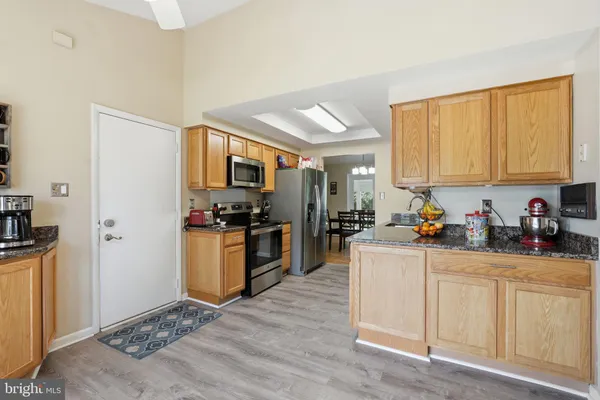 a kitchen with stainless steel appliances granite countertop a stove refrigerator and a microwave