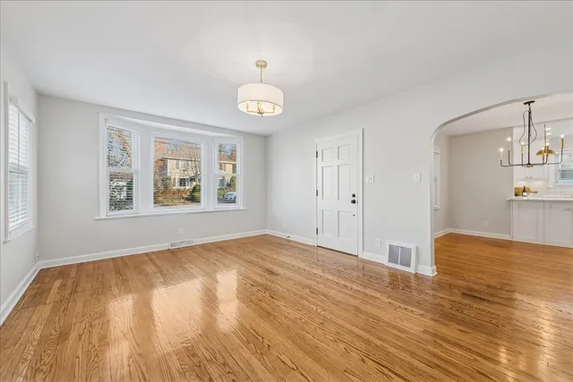 a view of empty room with wooden floor and window