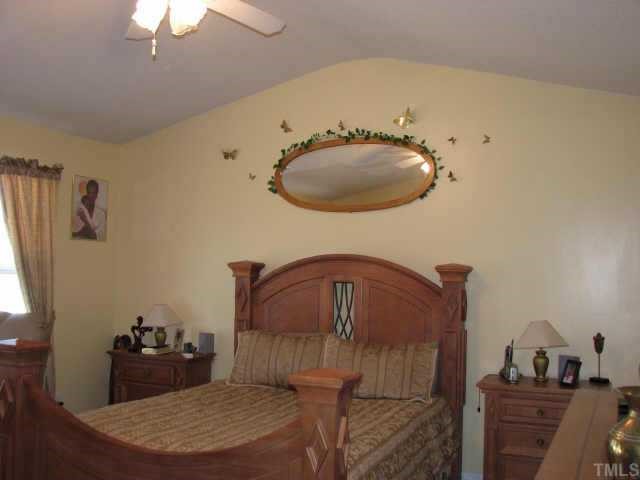 5604 Orchard Gate Way Raleigh, NC 27616 - Photo 2 of 8 a bedroom with a bed and a chandelier