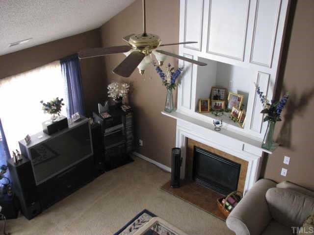 5604 Orchard Gate Way Raleigh, NC 27616 - Photo 3 of 8 a living room with furniture a flat screen tv and a fireplace
