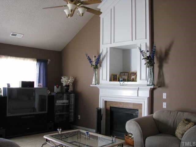 5604 Orchard Gate Way Raleigh, NC 27616 - Photo 7 of 8 a living room with furniture a fireplace and a flat screen tv