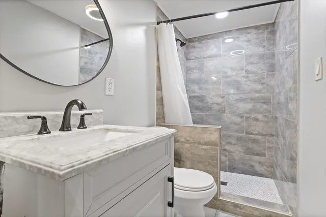 a bathroom with a sink a toilet and a mirror