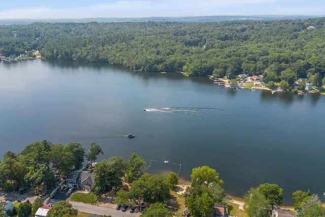 an aerial view of a house with a yard and lake view