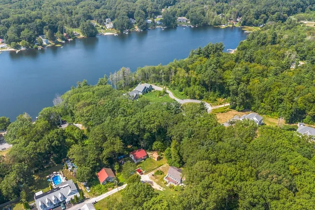 an aerial view of lake residential house with outdoor space and trees around