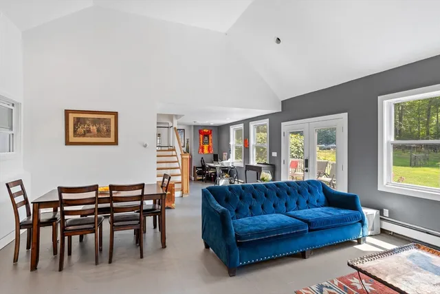 a living room with furniture a dining table and a window