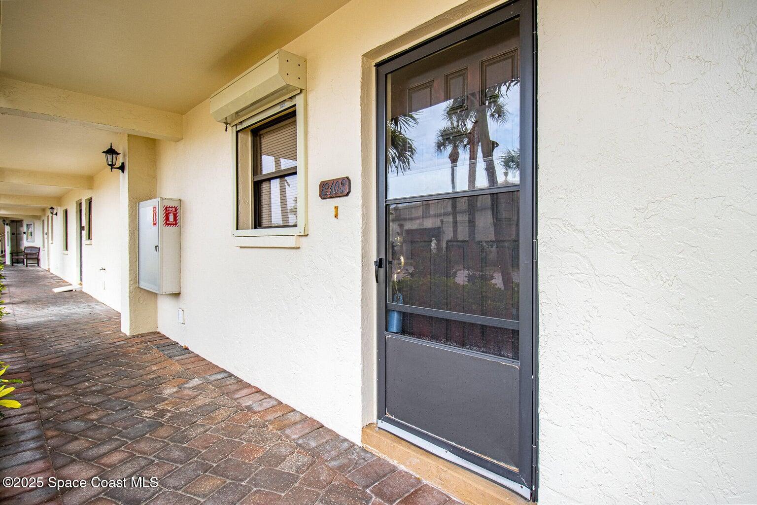 840 North Atlantic Avenue, Unit C103 Cocoa Beach, FL 32931 - Photo 1 of 30 a view of a hallway with wooden floor and a refrigerator