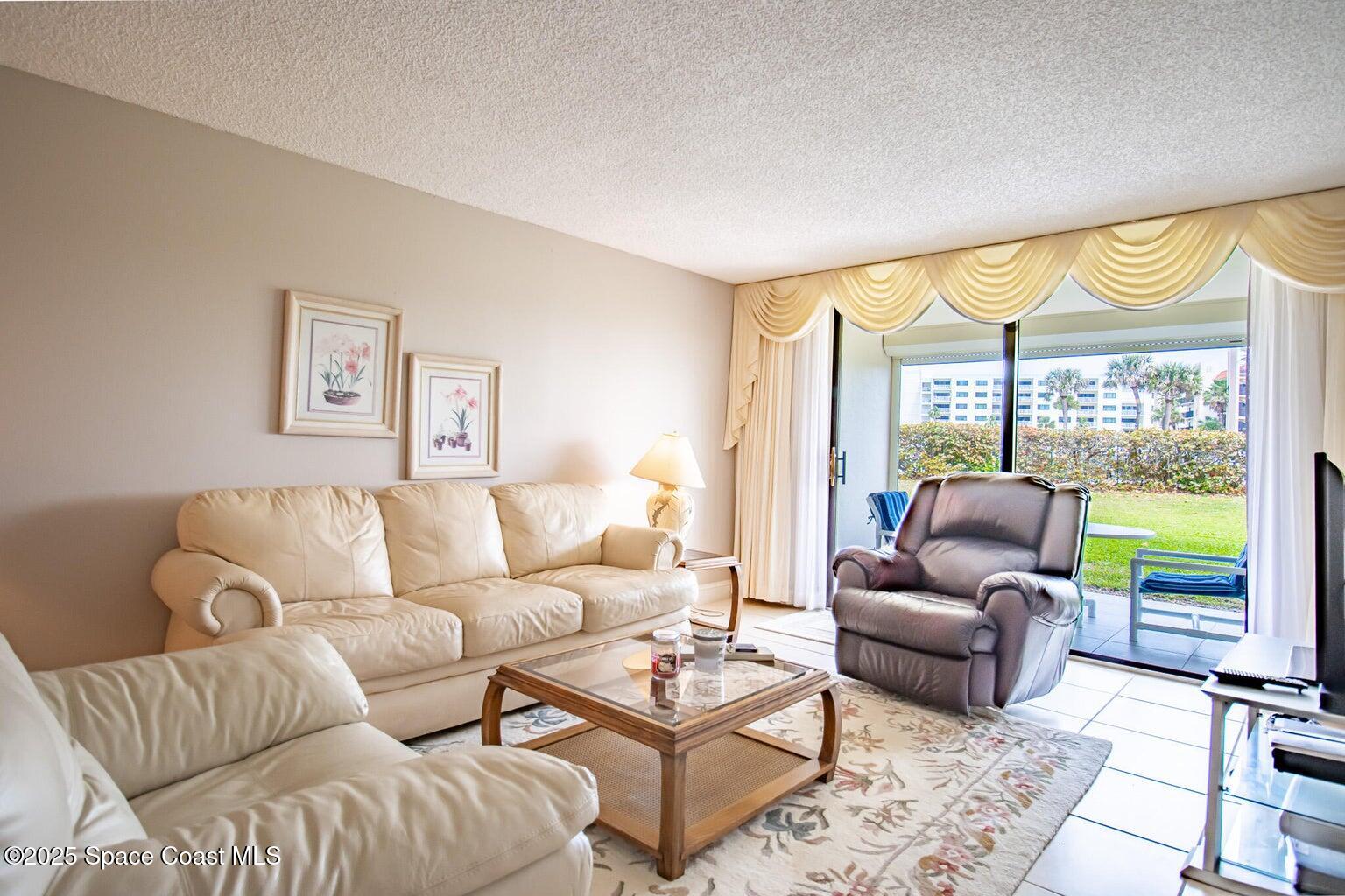 840 North Atlantic Avenue, Unit C103 Cocoa Beach, FL 32931 - Photo 12 of 30 a living room with furniture and a large window