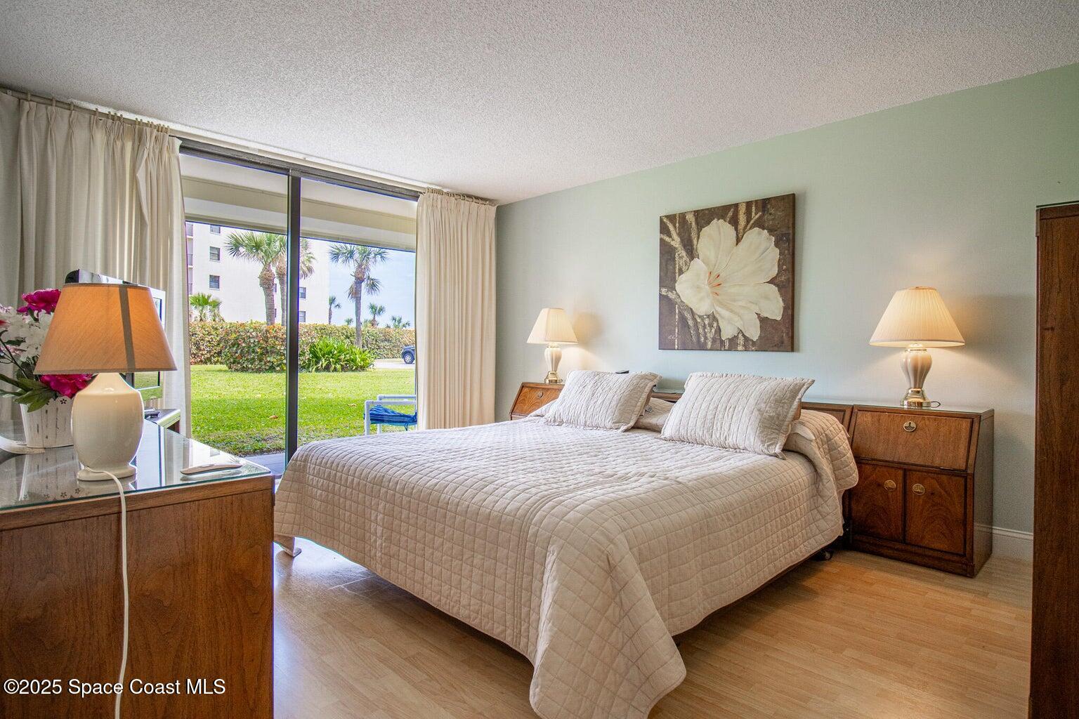 840 North Atlantic Avenue, Unit C103 Cocoa Beach, FL 32931 - Photo 14 of 30 a bedroom with a bed and large window