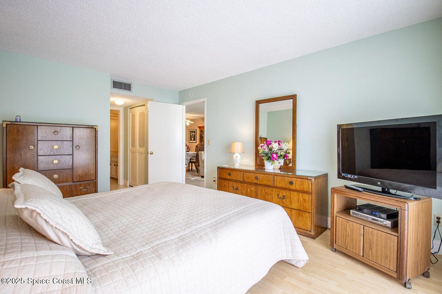 840 North Atlantic Avenue, Unit C103 Cocoa Beach, FL 32931 - Photo 15 of 30 a bedroom with a bed and a flat screen tv