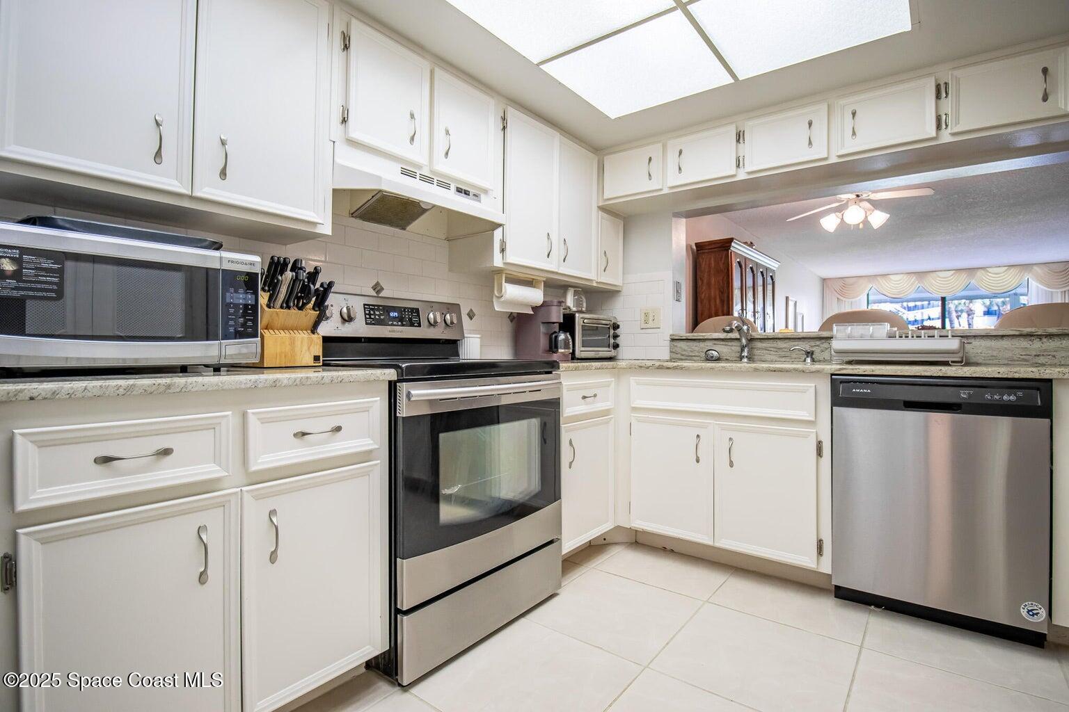 840 North Atlantic Avenue, Unit C103 Cocoa Beach, FL 32931 - Photo 2 of 30 a kitchen with cabinets stainless steel appliances and sink
