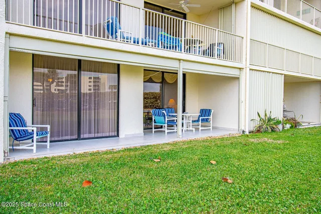 a view of a house with a yard and sitting area