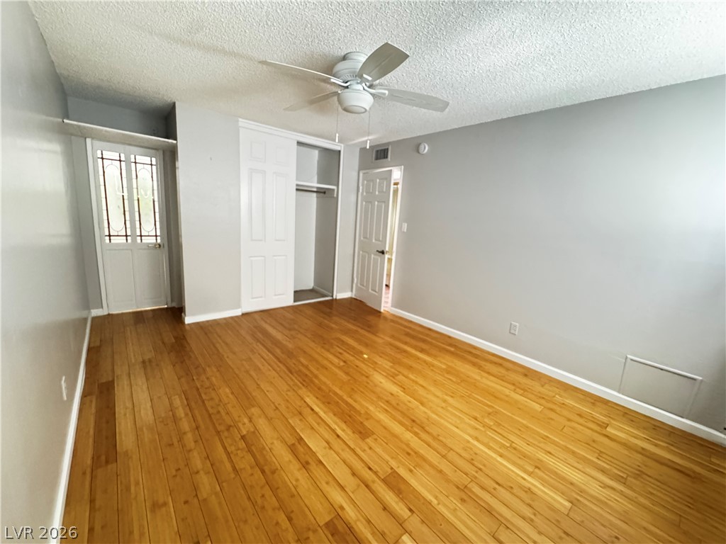 350 East Desert Inn Road, Unit C103 Las Vegas, NV 89109 - Photo 10 of 23 Hardwood floors and a ceiling fan create a comfortable and inviting atmosphere in this bedroom.