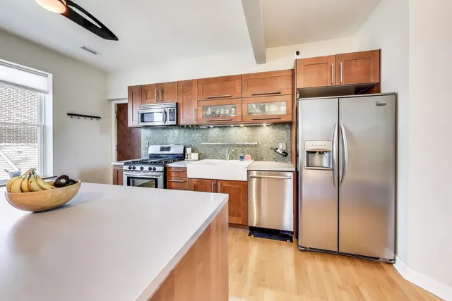a kitchen with stainless steel appliances a refrigerator sink and wooden floor
