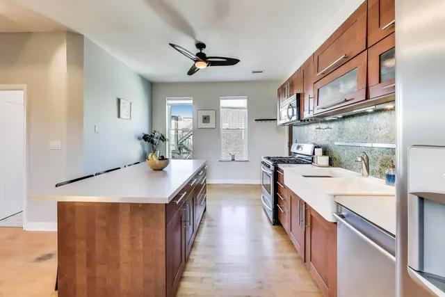 a large kitchen with stainless steel appliances a lot of counter space and a refrigerator