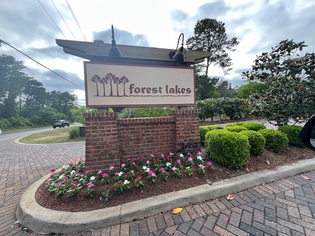 a sign that is sitting in front of flowers