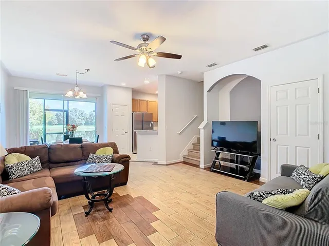 a living room with furniture a flat screen tv and a window