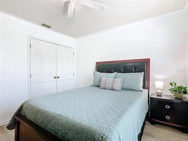 a bedroom with a bed and a potted plant
