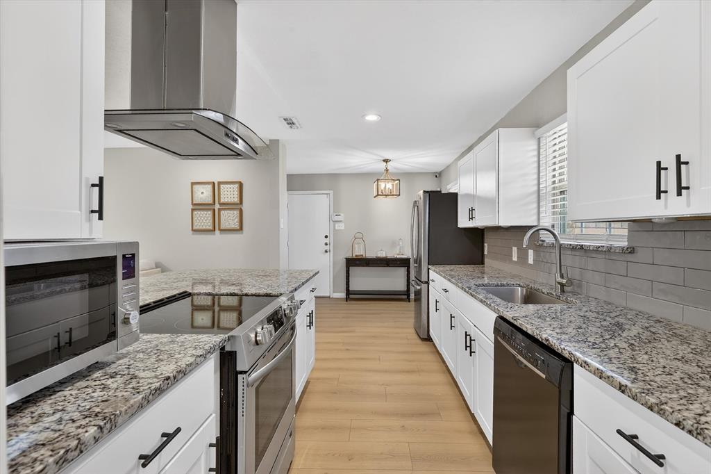 2920 Sharpview Lane Dallas, TX 75228 - Photo 14 of 34 Kitchen with stainless steel appliances, ventilation hood, white cabinetry, light wood-style floors, and light stone counters