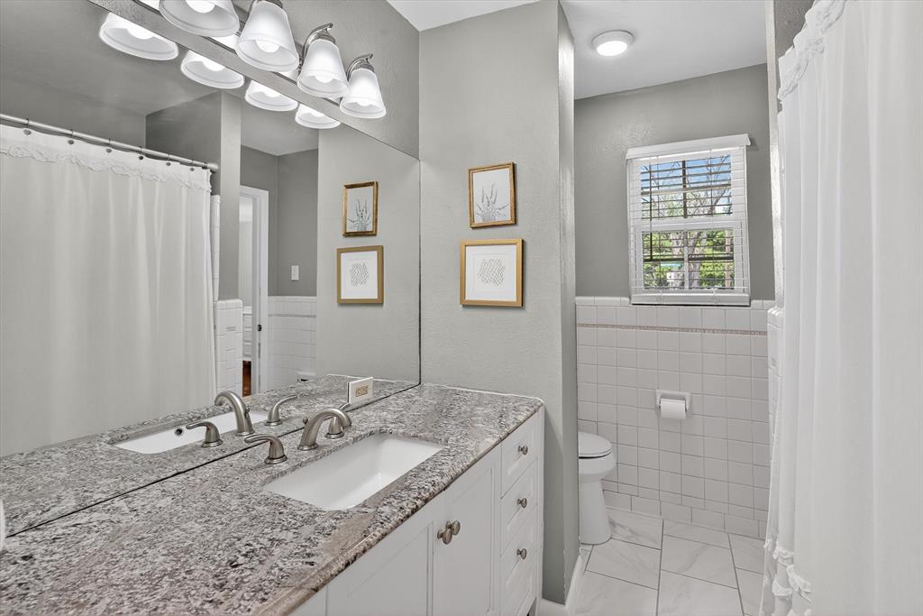 2920 Sharpview Lane Dallas, TX 75228 - Photo 20 of 34 Bathroom featuring a shower with curtain, vanity, and tile walls