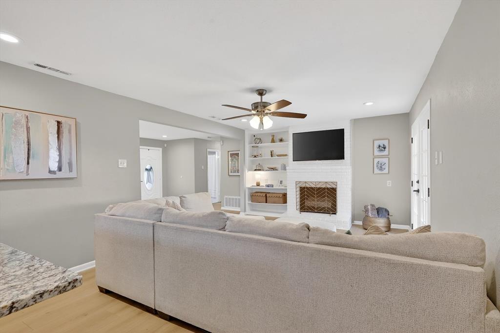 2920 Sharpview Lane Dallas, TX 75228 - Photo 9 of 34 Living area featuring a ceiling fan, recessed lighting, light wood finished floors, built in features, and a fireplace