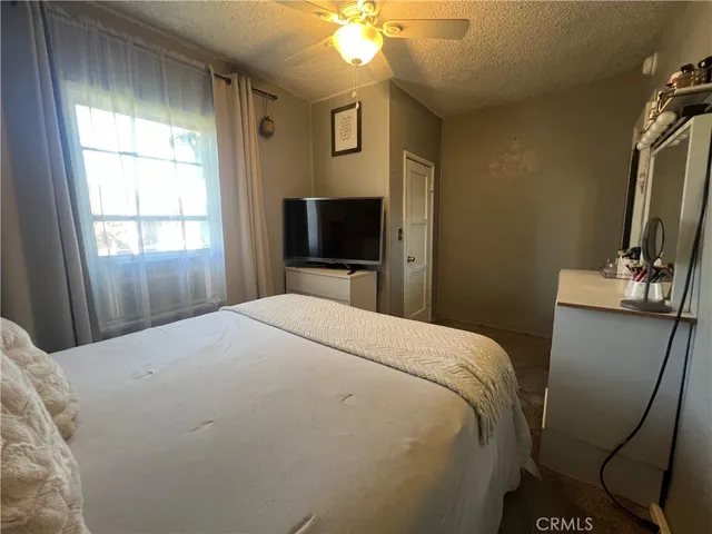 a bedroom with a bed and a flat tv screen on dresser