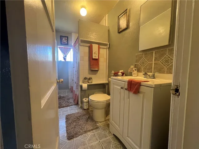 a bathroom with a granite countertop toilet and a sink
