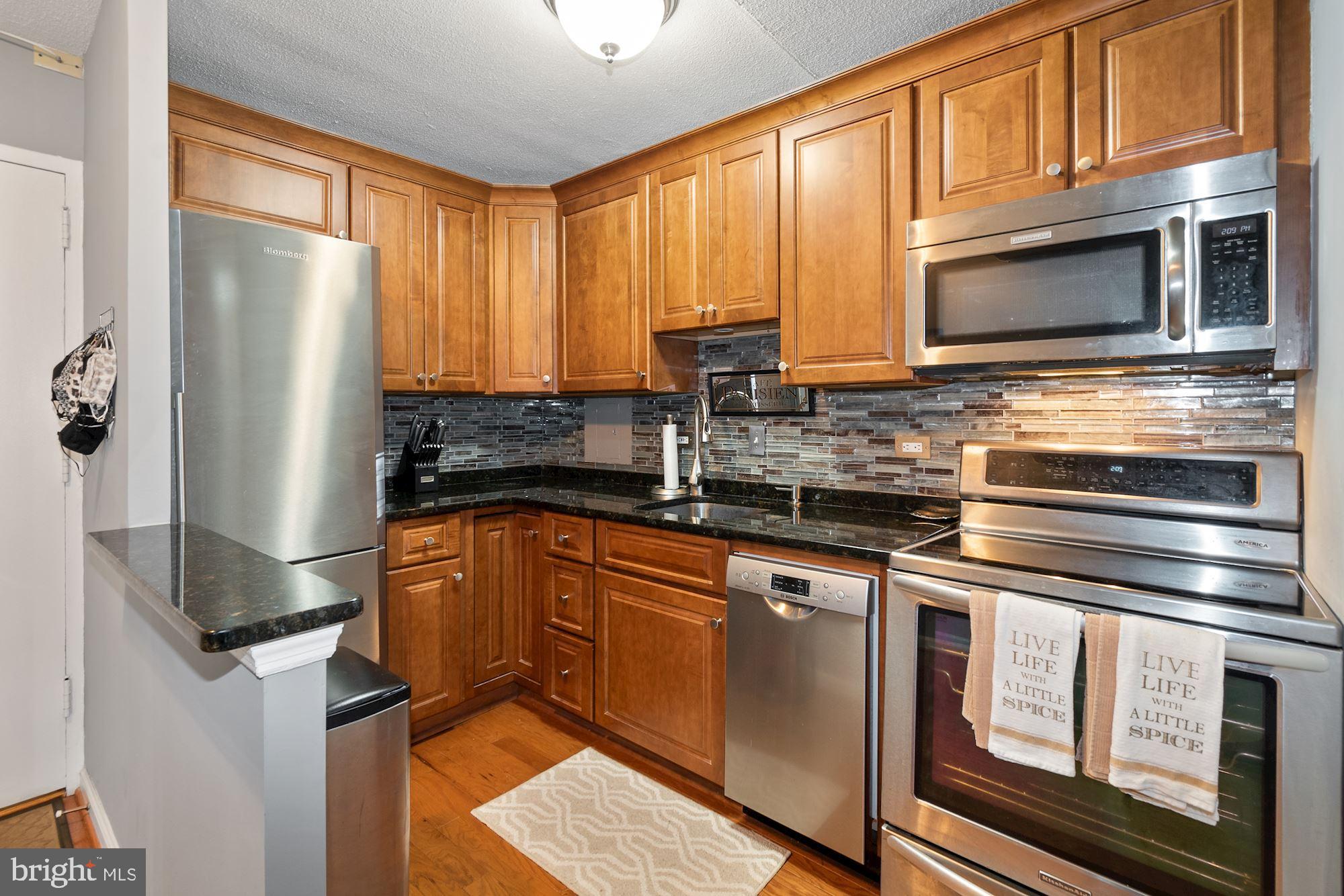 1311 Delaware Avenue Southwest, Unit S346 Washington, DC 20024 - Photo 7 of 23 a kitchen with stainless steel appliances granite countertop a refrigerator stove and microwave