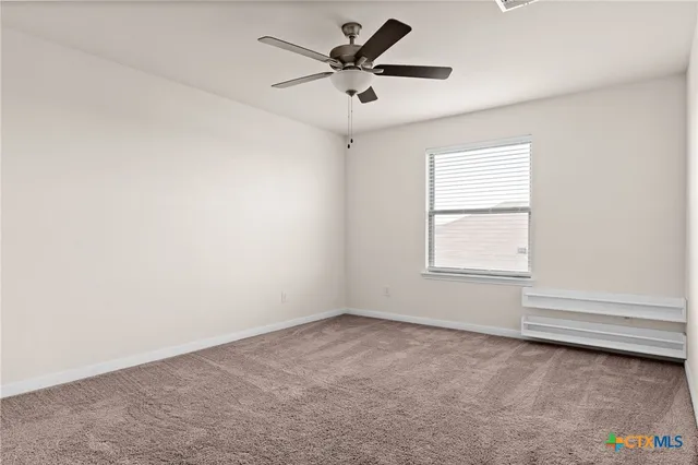 an empty room with a window and a ceiling fan