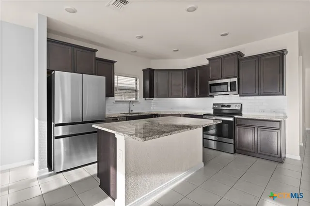 a kitchen with a refrigerator sink and stainless steel appliances