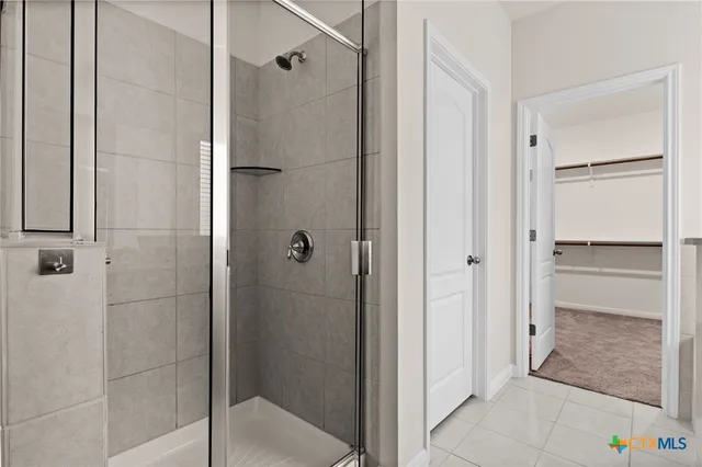 a bathroom with a shower and a glass door