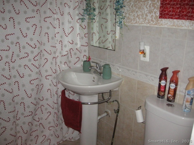 105 Edin Avenue Waterbury, CT 06706 - Photo 16 of 27 a bathroom with a sink and mirror with toilet