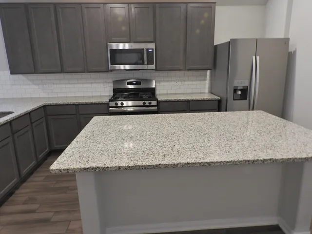 a kitchen with stainless steel appliances granite countertop a sink stove and cabinets