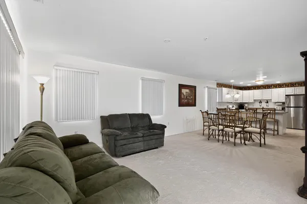 a living room with furniture and a flat screen tv with kitchen view
