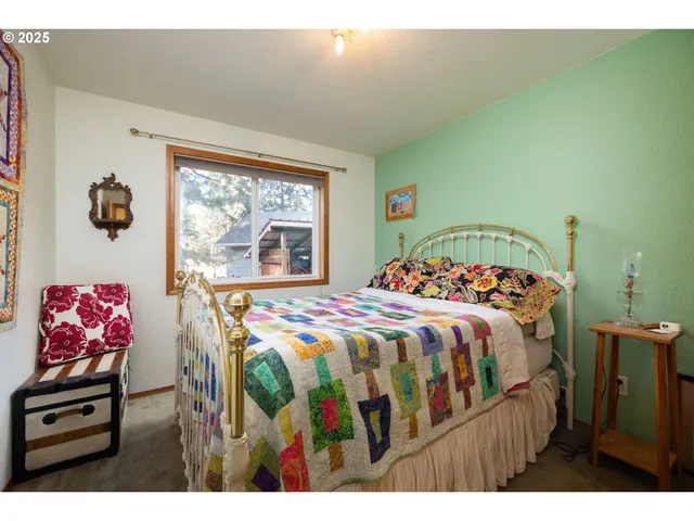 a bedroom with a bed and a painting on the wall