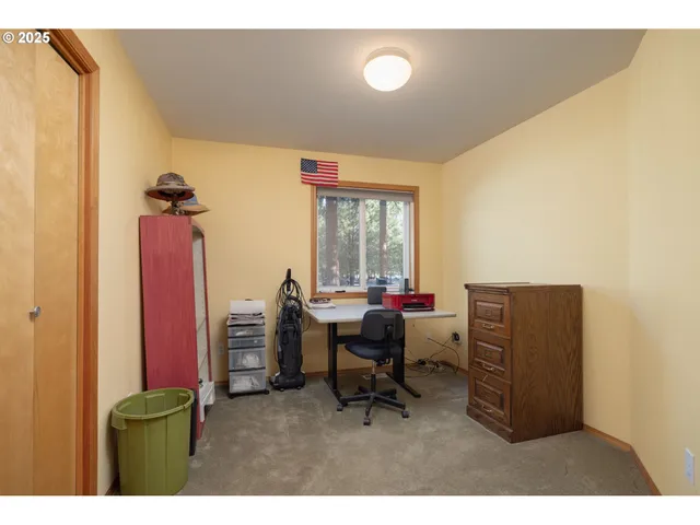 a view of a workspace with furniture and a window