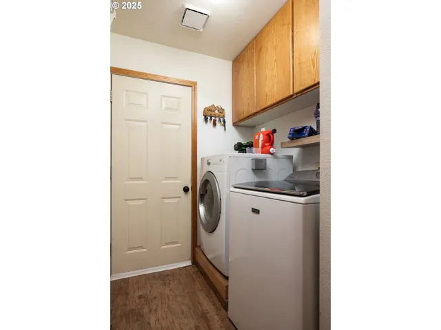 a storage room with water heater and refrigerator