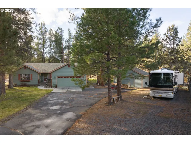 a view of a yard in front of a house with a tree